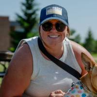 A racer and her dog smile for a photo.